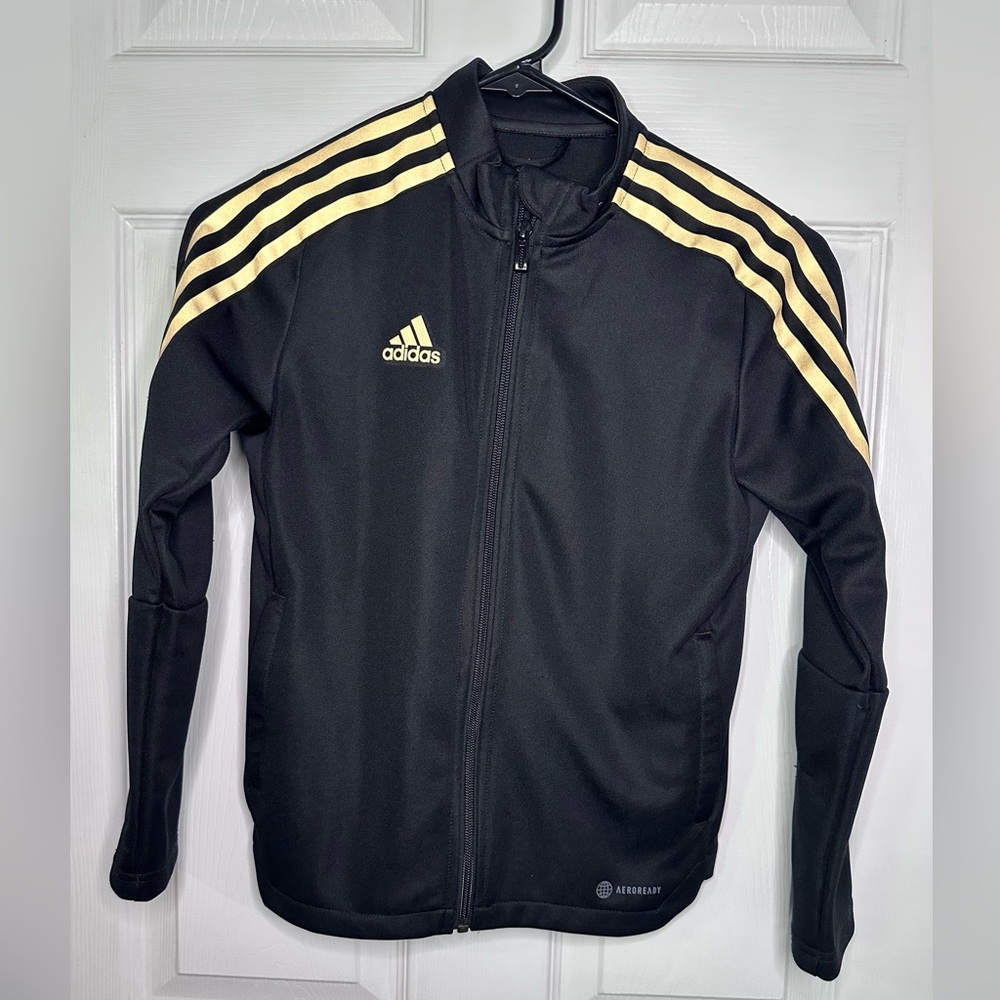 Kids Adidas Black and Gold Tiro Track Jacket.
